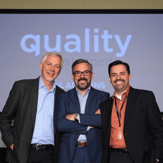 Three quality managers standing next to each other smiling
