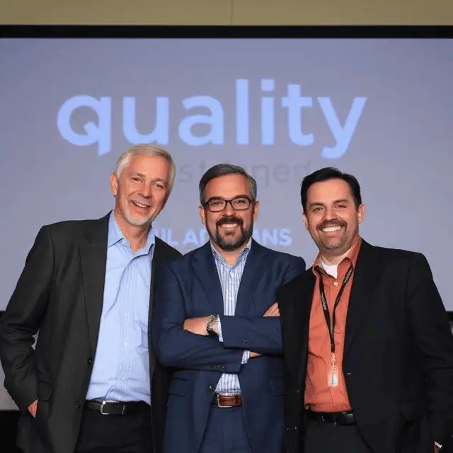 Three quality managers standing next to each other smiling
