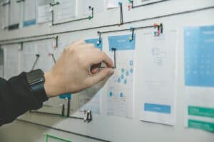 A hand pointing at a map on a board