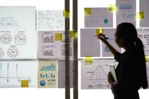 Business woman analyzing charts and graphs hanging on the wall