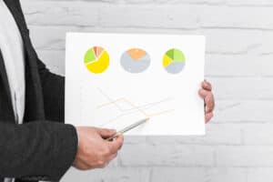 Businessman pointing at a paper showing diagrams and reports